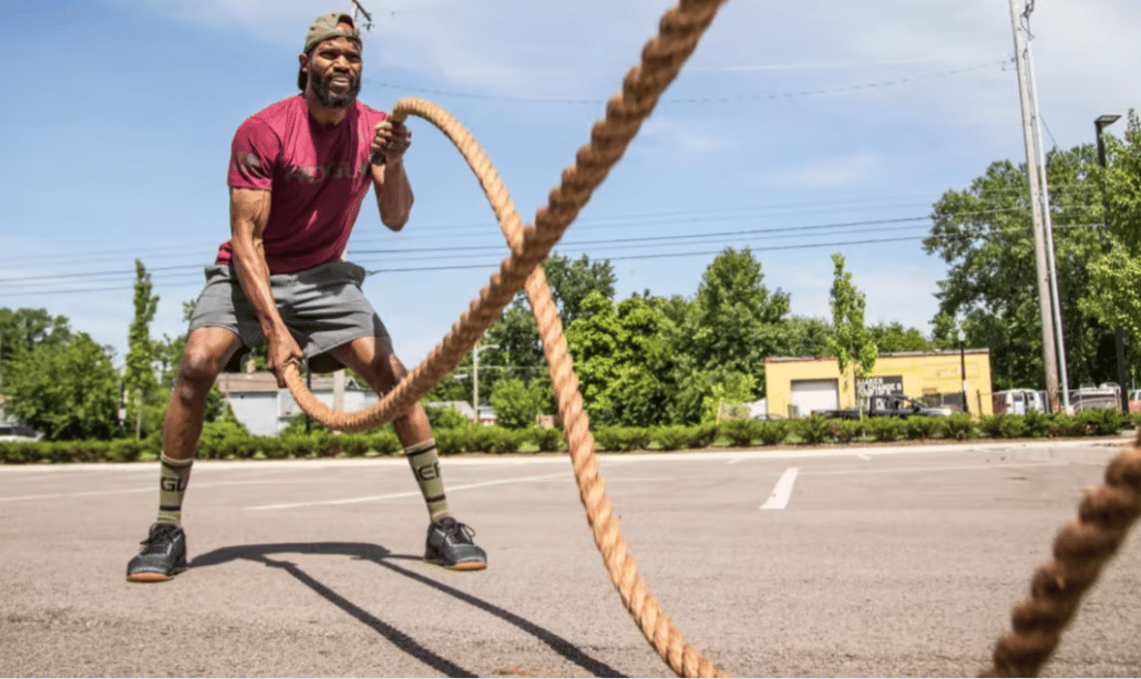 sportif en plein exercise de battle rope core